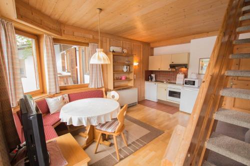 a kitchen and living room with a table and chairs at Waterfront Apartments Zell am See - Steinbock Lodges in Zell am See