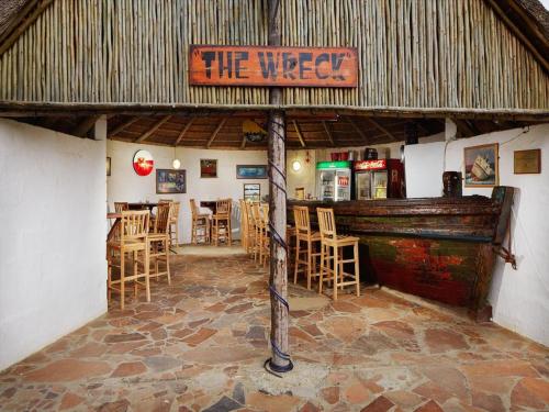 a restaurant with a sign that reads the vibeat with chairs at Uberkei in Coffee Bay
