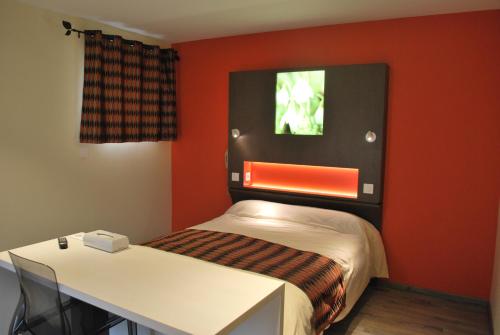 Mały pokój z łóżkiem i biurkiem w obiekcie Hôtel Les Perce-Neige w mieście Bonnétage
