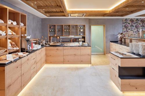 a large kitchen with wooden cabinets and counters at Naturhotel Edelweiss Wagrain in Wagrain