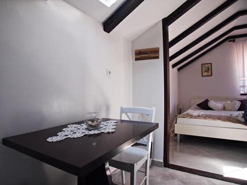 a dining room with a table and a bed at Rooms & Studio Stipcic in Trogir