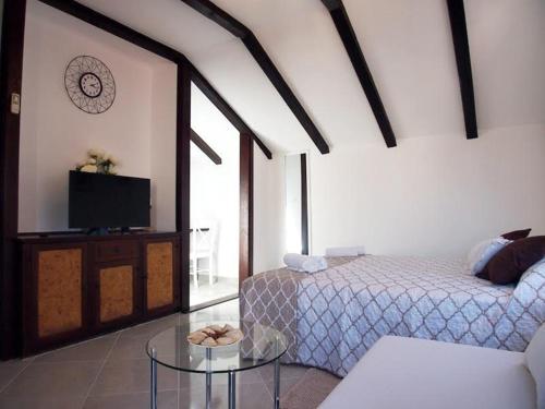 a bedroom with two beds and a tv and a table at Rooms & Studio Stipcic in Trogir