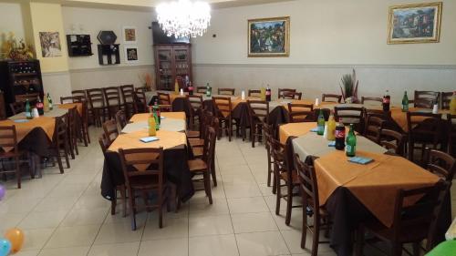 a dining room with tables and chairs with bottles on them at La Piana Hotel in Tito