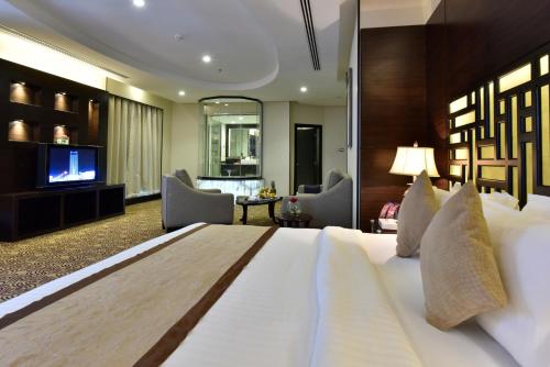 a bedroom with a large bed and a living room at Awaliv Hotel in Taif