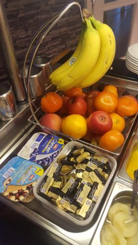 a tray of fruit with bananas and oranges and milk at Queens Plaza Hotel in Blackpool