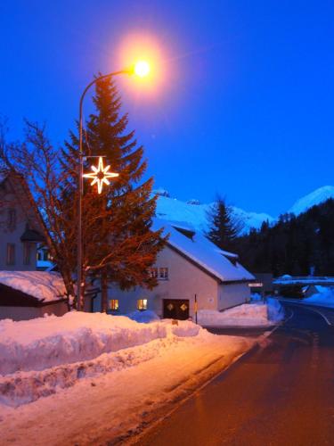 a street light with a star on it in the snow at Jugendherberge Hospental in Hospental