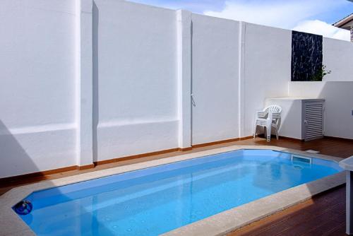 a swimming pool on a balcony with a white privacy fence at Sunset Holiday Home in Fernao Ferro