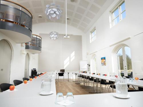 a conference room with white tables and chairs at Haraldskær Sinatur Hotel & Konference in Vejle