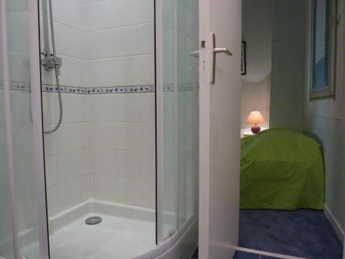 une douche avec une porte vitrée dans une salle de bain dans l'établissement Au Coeur du vieux Nice, à Nice