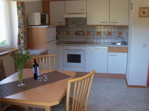 a kitchen with a wooden table with a bottle of wine at Haus Mary in Russbach am Pass Gschütt