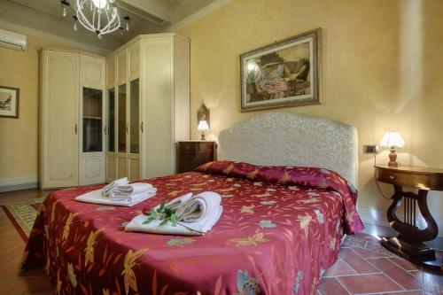 a bedroom with a bed with towels on it at Pergola Apartment in Florence