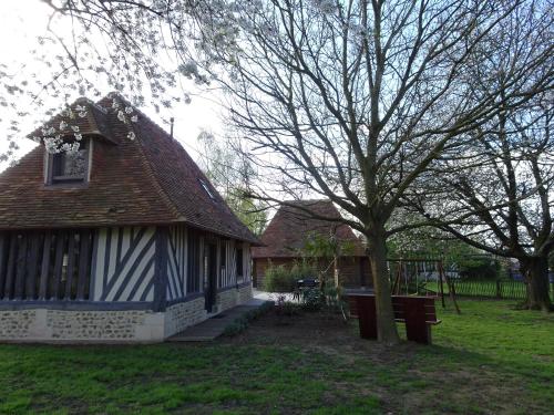 a blue and white house with a tree and a bench at Gîte Falafa Normand in Pont-lʼÉvêque