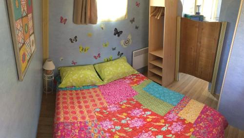 a bedroom with a bed with a colorful quilt at Domaine de Labelo in Commensacq