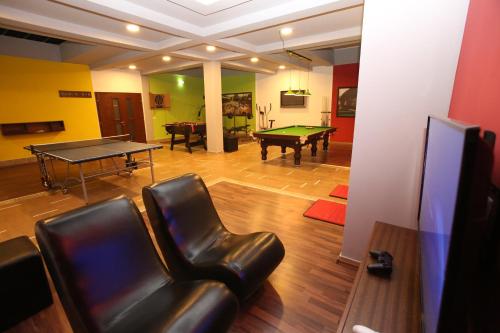a living room with a ping pong table and leather chairs at Hotel OK in Prizren