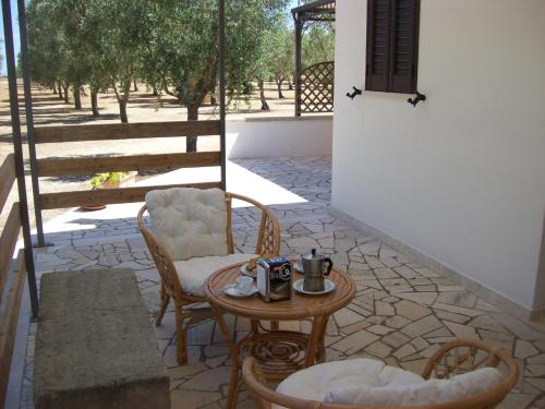 d'une terrasse avec une table, des chaises et une table. dans l'établissement Otranto Le Sancinare, à Casamassella