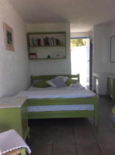 a bedroom with a green bed and a window at Rosys Little Village in Skala