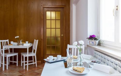 a dining room with a white table and chairs at Bonjour Bonheur in Avellino