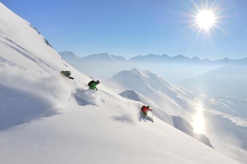 two people skiing down a snow covered mountain at Ibex Lodge in Sankt Anton am Arlberg