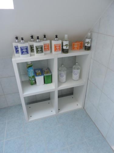 a white shelf in a bathroom with bottles of soap at Ferienwohnung Eckberger Weinstrasse 139 in Gamlitz