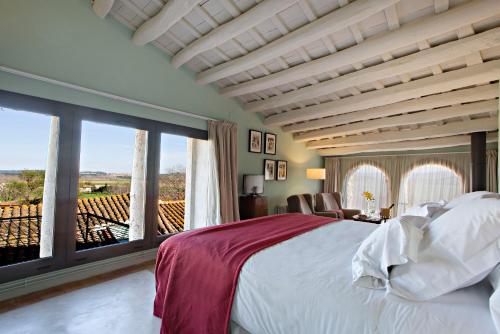 a bedroom with a large bed and a large window at Encís d'Empordà -Adults Only- in Casavells