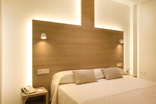 a bedroom with a bed and a telephone at Hotel Carlos I in Benidorm