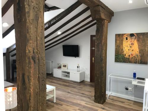 a living room with white walls and wooden beams at AIRVA: Apartamento Teresa Gil in Valladolid