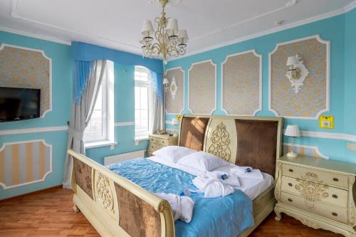 a bedroom with blue walls and a bed with towels at Princess Elisa Hotel in Zelenogradsk