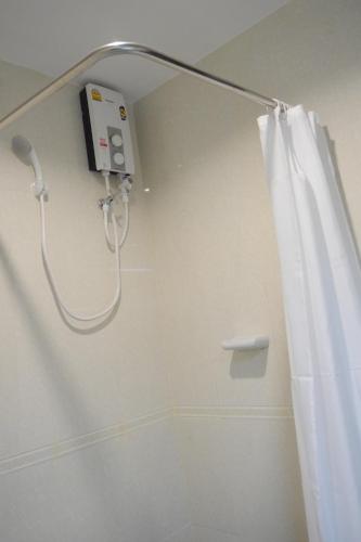 a shower in a bathroom with a shower curtain at Lertnimit Hotel in Chaiyaphum
