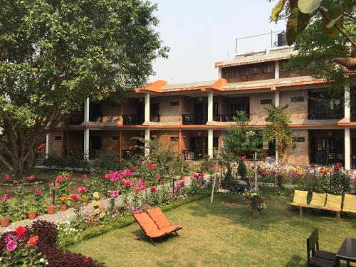 a building with a garden with flowers in front of it at Chautari Garden Resort in Sauraha