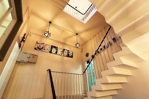 a staircase in a house with white stairs and a skylight at Hub Hostel Hatyai in Hat Yai