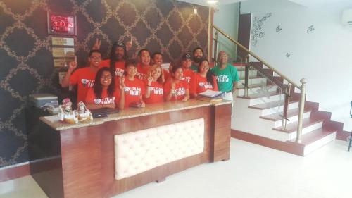 a group of people posing for a picture behind a counter at Hotel Delhi Aerocity in New Delhi