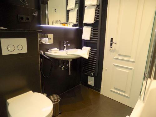 a bathroom with a sink and a toilet at Hotel Strandhörn in Wenningstedt