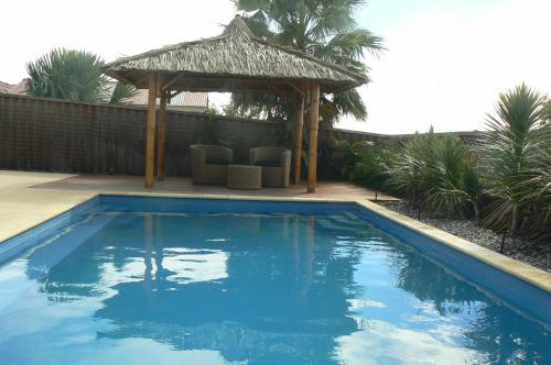 a swimming pool with a gazebo in a yard at La Mer - Home with a Pool in Quinns Rocks