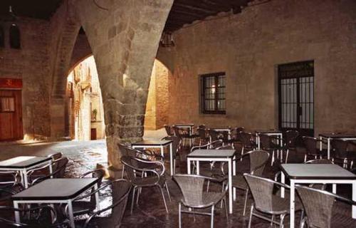 una habitación vacía con mesas y sillas en un edificio en Hostal Las Coronas en Sos del Rey Católico