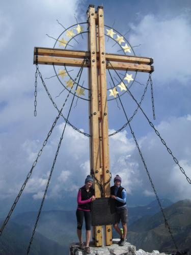 two people standing in front of a cross on top of a mountain at Troadkasten in Kötschach