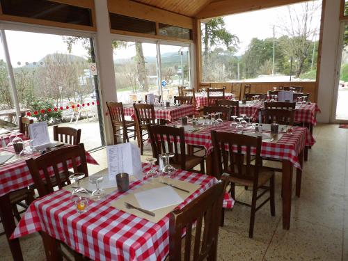 - un restaurant avec des tables en tissu de table rouge et blanc dans l'établissement Le Relais de l'Artuby, à Séranon