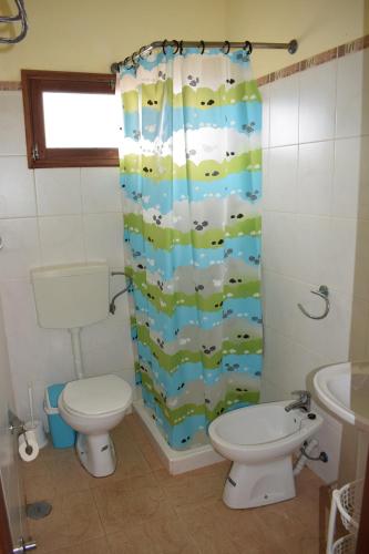 a bathroom with a toilet and a shower curtain at Apartamento Fritzi in Ponta do Sol