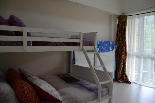 Apartment in Pico De Loro في ناسوغبو: غرفة نوم بسريرين بطابقين ونافذة