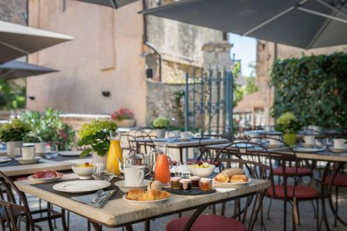 a table with plates of food on top at Hôtel Aux Vieux Remparts, The Originals Relais in Provins