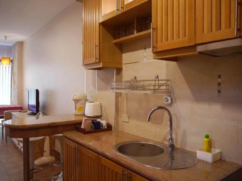 a kitchen with a sink and wooden cabinets at Apartments At View Talay in Pattaya South