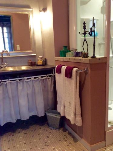 La salle de bains est pourvue d'un lavabo et de serviettes sur un portant. dans l'établissement Nid d'Artiste, à Saint-Quentin-la-Poterie