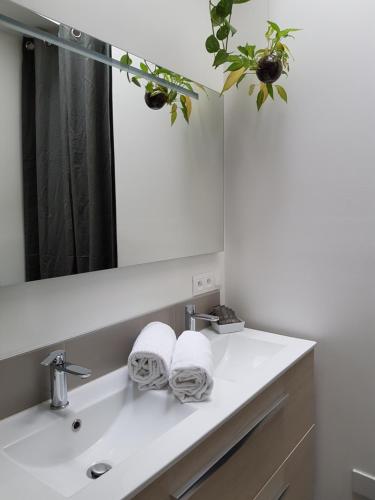 a bathroom with a sink with a mirror and towels at Hotel La Marine, Vieux Port in La Rochelle