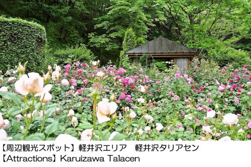 a garden filled with flowers and a gazebo at Karuizawakurabu Hotel 1130 Hewitt Resort in Tsumagoi