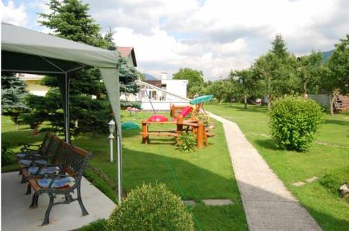 a group of benches sitting under a tent in a yard at Penzión Šuštiak in Terchová