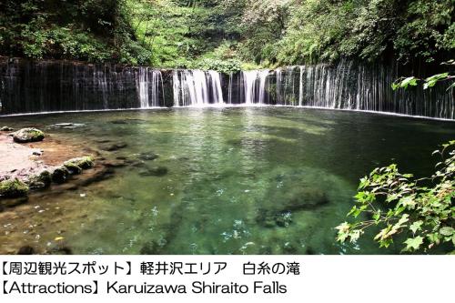 a waterfall in front of a pool of water at Karuizawakurabu Hotel 1130 Hewitt Resort in Tsumagoi