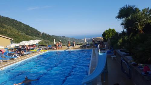a large swimming pool with people in a resort at da Marinella in Diano Borello