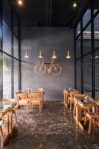 a restaurant with wooden tables and a bike hanging on the wall at La Pause Hatyai in Hat Yai