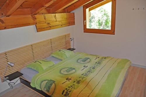 een slaapkamer met een bed in een kamer met een raam bij Casa Ansiel - 2.5 Zimmer Ferienwohnung am Sonnenhang von Falera in Falera