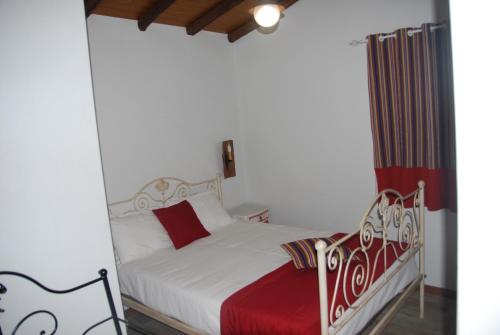 a bedroom with a white bed with a red blanket at Casas no Terreiro in Penacova