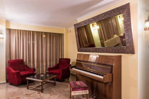 a living room filled with furniture and a piano at Sunset Hotel in Corfu